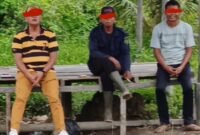 Kanit Polsek Tanjung Pura IPTU Kaspar Napitupulu (kiri) duduk bersama Sup (tengah). Sup diduga berperan melakukan pengukuruan kawasan hutan yang diperjualbelikan mafia.