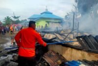 Petugas Damkar memadamkan api yang membakar rumah semi permanen milik Nurlella.