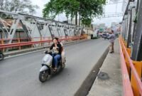Warga melintasi Jembatan Sei Batang Serangan di Kecamatan Tanjung Pura, Langkat.