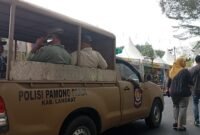 Petugas Satpol PP Langkat memberikan imbauan di areal pameran dengan mobil patroli.