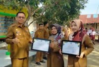 Plt Kadisdik Langkat Robert Hendra Ginting AP MSi memberikan piagam penghargaan kepada Dian Mirza di di SDN 056636 Kelantan.