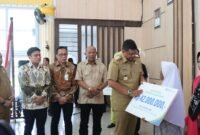 Gubernur Sumatera Utara Bobby Afif Nasution dan Pimpinan DPRD Sumut Ricky Anthony menterahkan BPJS Ketenagakerjaan kepada nelayan Kabupaten Langkat.