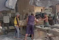 Pekerja PT KPU tidak menggunakan APD saat menggergaji kayu.