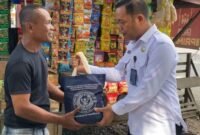 Karutan Kelas IIB Tanjung Pura Jimri Anton S Nababan memberikan paket bahan pangan kepada warga.