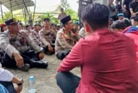 Aparat kepolisian dan anggota DPRD Langkat duduk bersila saat mendengar aspirasi massa.