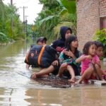 Warga menggunakan rakit untuk mengevakuasi para korban banjir