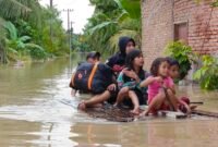 Warga menggunakan rakit untuk mengevakuasi para korban banjir.