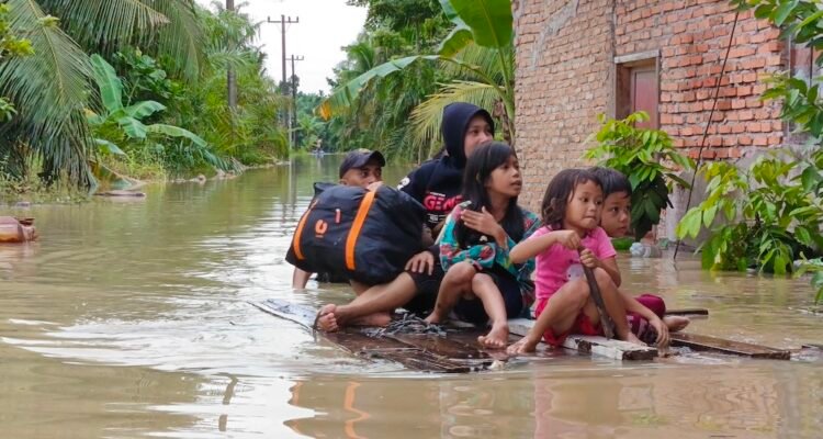 Warga menggunakan rakit untuk mengevakuasi para korban banjir