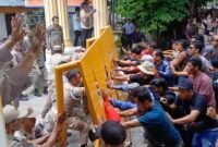 Gerbang Kantor Bupati Langkat dirubuhkan ribuan massa korban banjir yang menuntut haknya.