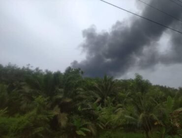 Asap membumbung tinggi yang diduga disebabkan dapur penyulingan minyak mentah (Kondensat) ilegal terbakar di Desa Air Hitam, Kecamatan Gebang, Langkat.