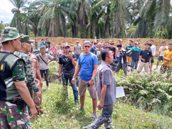 
Petugan pengaman PTPN 2 menghalau warga yang menghalangi pembuatan parit isolasi.