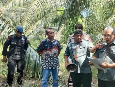 Panitera PN Stabat membacakan penetapan putusan pengadilan di lokasi lahan yang akan dieksekusi.