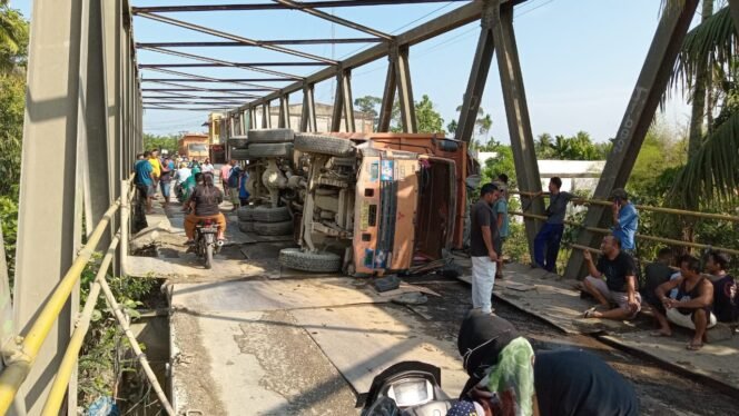 
Truk pengangkut sirtu yang terguling di Jembatan Sei Air Tenang, Kecamtan Batang Serangan, Langkat, Kamis (21:3:2024) pagi.