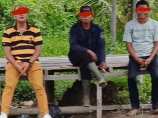 Kanit Polsek Tanjung Pura IPTU Kaspar Napitupulu (kiri) duduk bersama Sup (tengah). Sup diduga berperan melakukan pengukuruan kawasan hutan yang diperjualbelikan mafia.