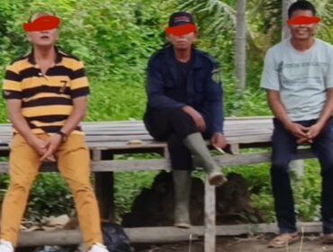 Kanit Polsek Tanjung Pura IPTU Kaspar Napitupulu (kiri) duduk bersama Sup (tengah). Sup diduga berperan melakukan pengukuruan kawasan hutan yang diperjualbelikan mafia.
