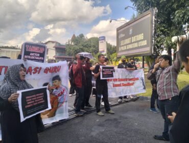 Para guru honorer melakukan orasi dan menyerahkan award di Mapolda Sumut.
