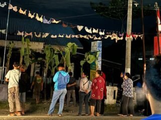 Warga desa berkerumun saat menggantungkan bra di Kantor Desa Serapuh Asli, Kecamatan Tanjung Pura, Langkat.