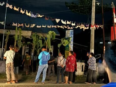 Warga desa berkerumun saat menggantungkan bra di Kantor Desa Serapuh Asli, Kecamatan Tanjung Pura, Langkat.