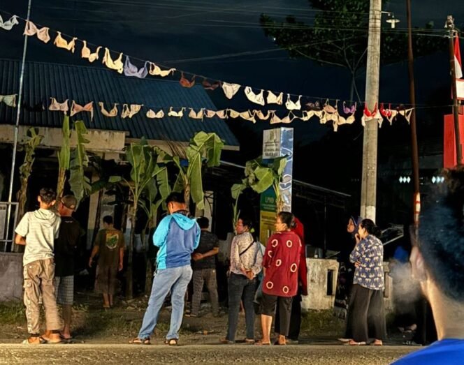 
Warga desa berkerumun saat menggantungkan bra di Kantor Desa Serapuh Asli, Kecamatan Tanjung Pura, Langkat.