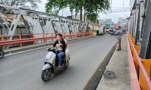 Warga melintasi Jembatan Sei Batang Serangan di Kecamatan Tanjung Pura, Langkat