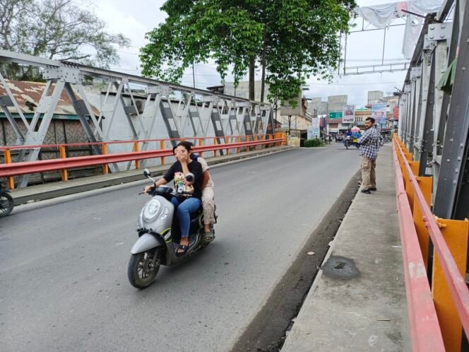
Warga melintasi Jembatan Sei Batang Serangan di Kecamatan Tanjung Pura, Langkat.