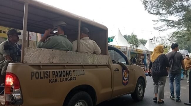 Petugas Satpol PP Langkat memberikan imbauan di areal pameran dengan mobil patroli.