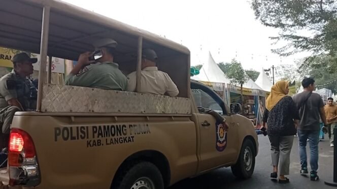 
Petugas Satpol PP Langkat memberikan imbauan di areal pameran dengan mobil patroli.