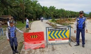 Petugas Dihub Langkat memasang rambu di sekitar jalan yang putus di Dusun Titi Kurus, Desa Karya Jadi, Kecamatan Batang Serangan