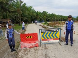 Petugas Dihub Langkat memasang rambu di sekitar jalan yang putus di Dusun Titi Kurus, Desa Karya Jadi, Kecamatan Batang Serangan.
