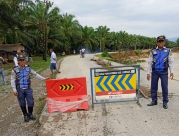 Petugas Dihub Langkat memasang rambu di sekitar jalan yang putus di Dusun Titi Kurus, Desa Karya Jadi, Kecamatan Batang Serangan.