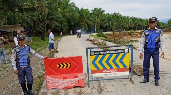 Petugas Dihub Langkat memasang rambu di sekitar jalan yang putus di Dusun Titi Kurus, Desa Karya Jadi, Kecamatan Batang Serangan.
