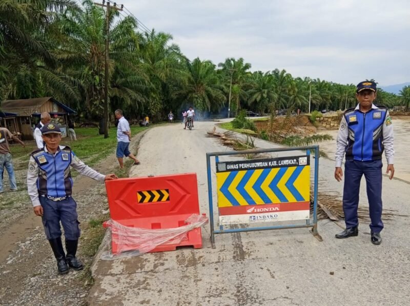 Petugas Dihub Langkat memasang rambu di sekitar jalan yang putus di Dusun Titi Kurus, Desa Karya Jadi, Kecamatan Batang Serangan.