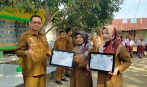 Plt Kadisdik Langkat Robert Hendra Ginting AP MSi memberikan piagam penghargaan kepada Dian Mirza di di SDN 056636 Kelantan