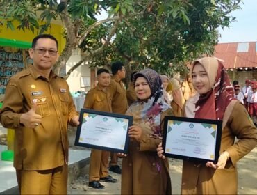 Plt Kadisdik Langkat Robert Hendra Ginting AP MSi memberikan piagam penghargaan kepada Dian Mirza di di SDN 056636 Kelantan.