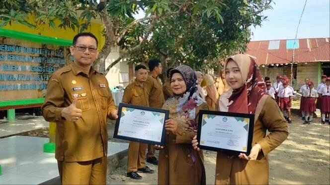 
Plt Kadisdik Langkat Robert Hendra Ginting AP MSi memberikan piagam penghargaan kepada Dian Mirza di di SDN 056636 Kelantan.