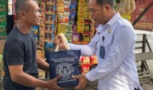 Karutan Kelas IIB Tanjung Pura Jimri Anton S Nababan memberikan paket bahan pangan kepada warga