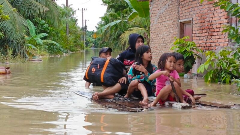 Warga menggunakan rakit untuk mengevakuasi para korban banjir.